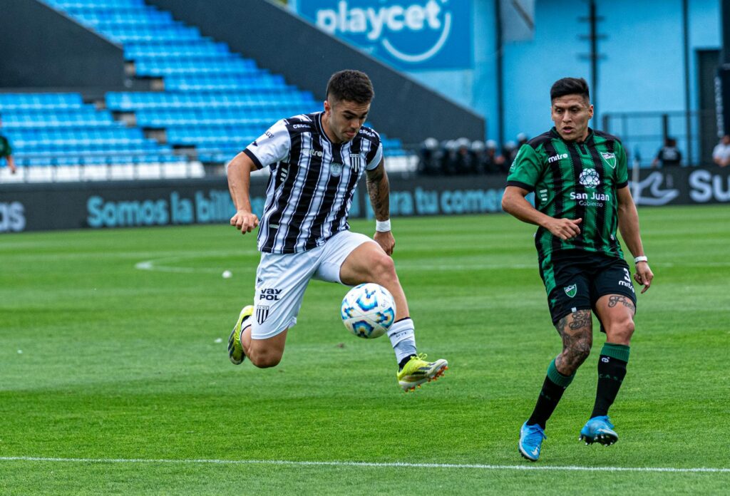 Intense football match moment with players in motion on the field.